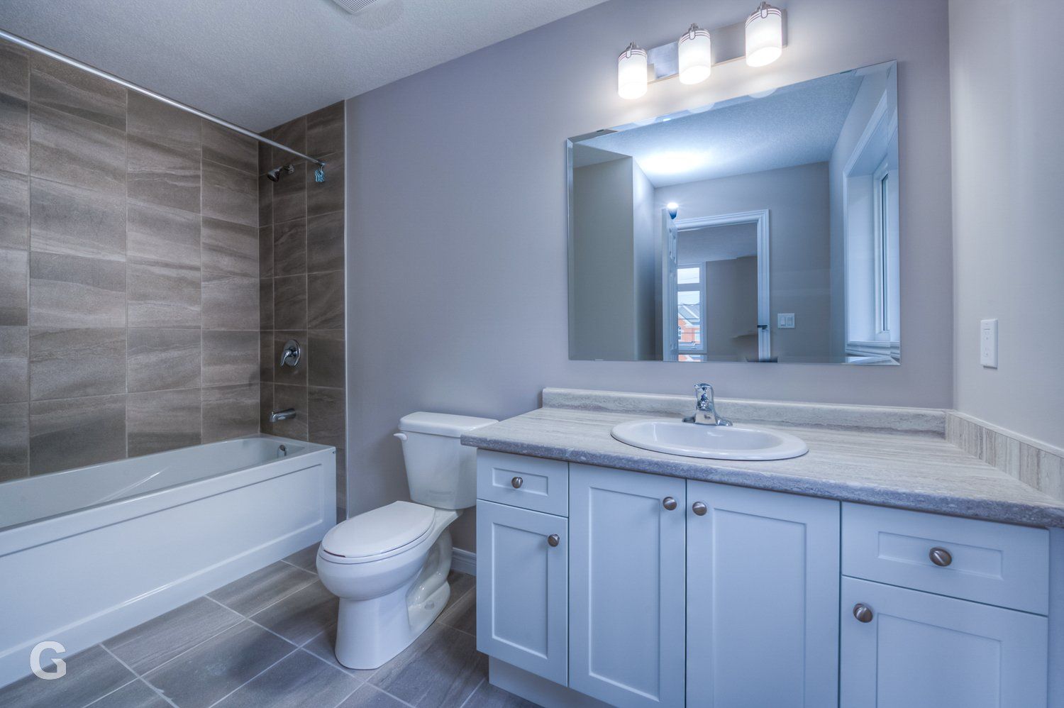 A bathroom with a toilet , sink , bathtub and mirror.