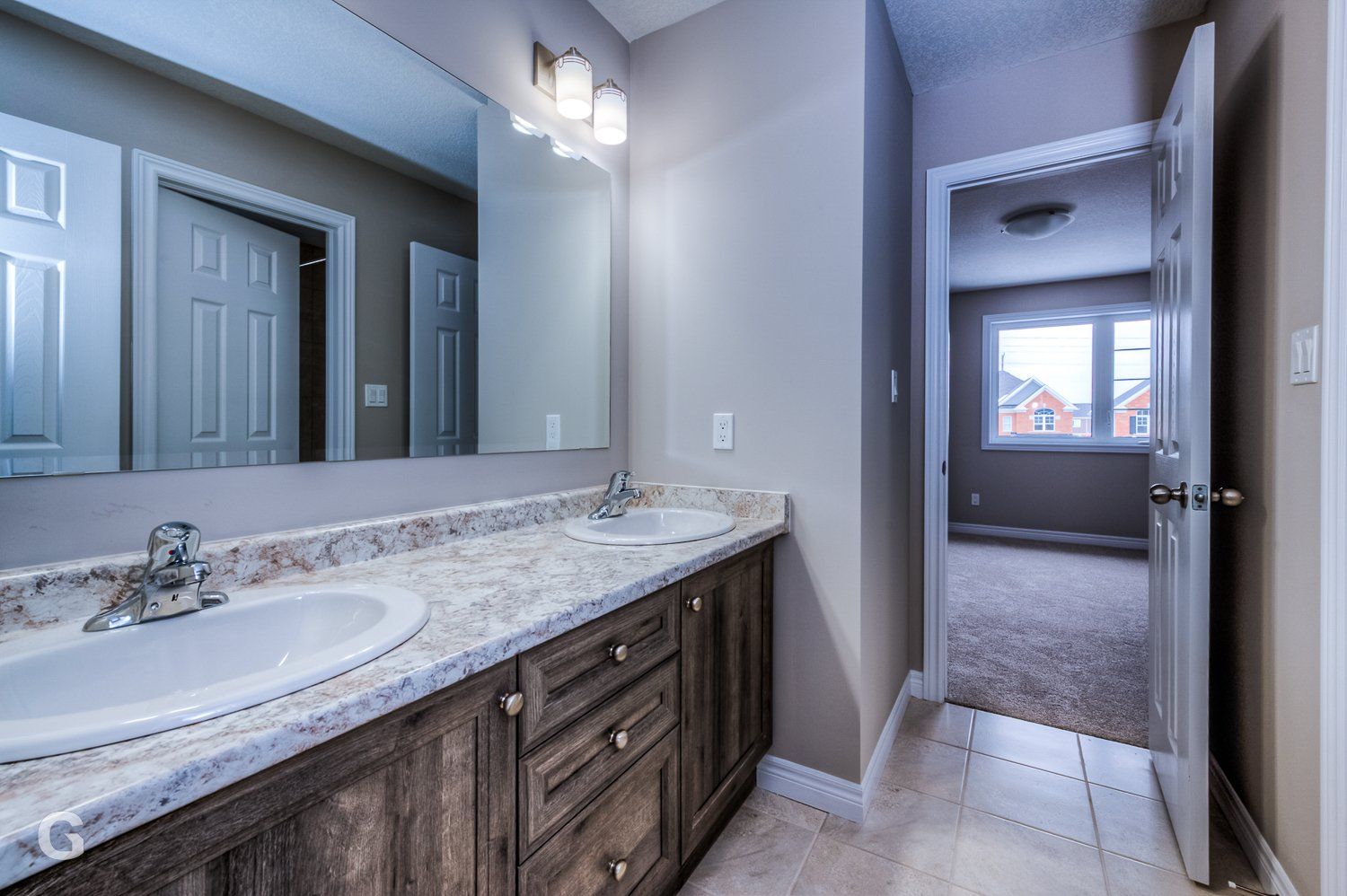A bathroom with two sinks and a large mirror.