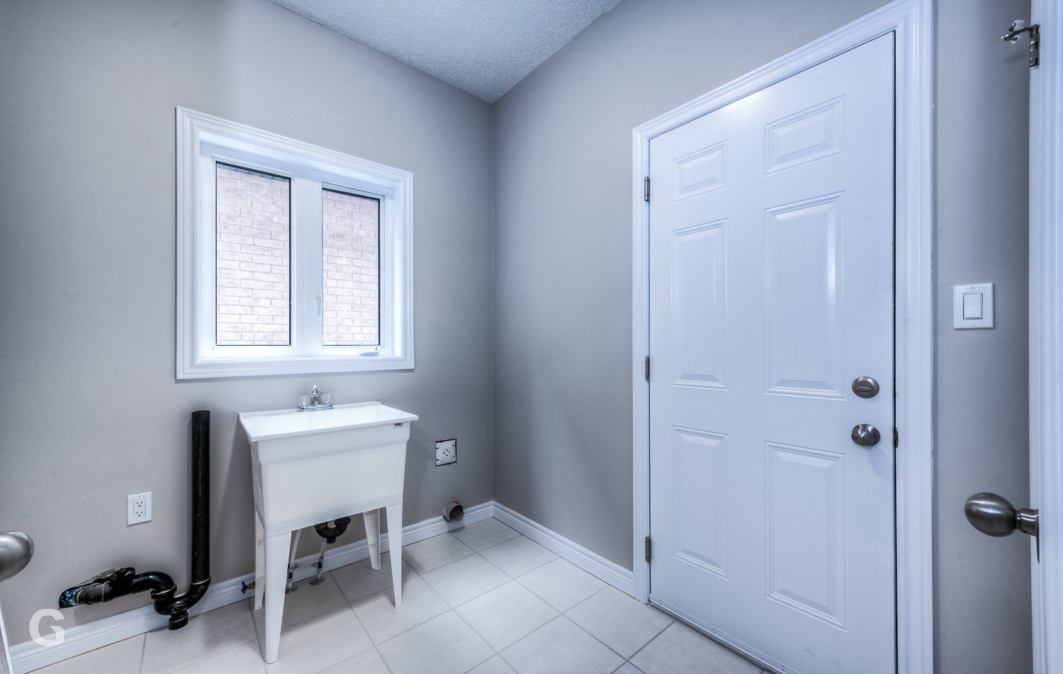 A laundry room with a sink and a window.
