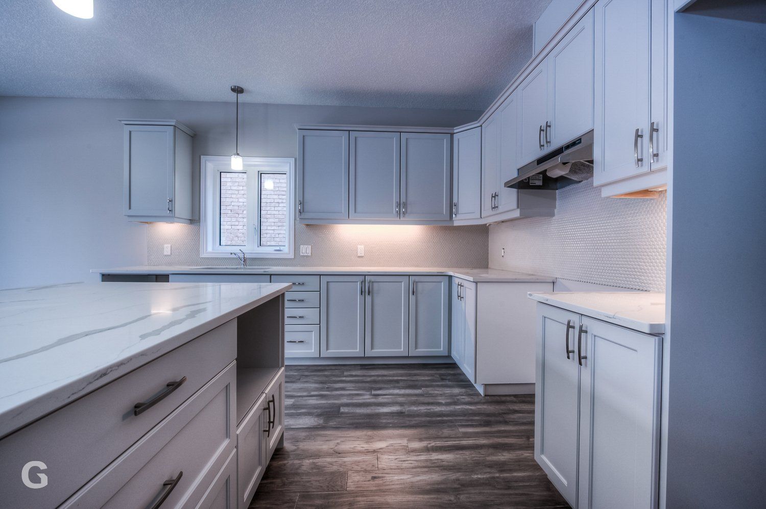 A kitchen with white cabinets and a large island in the middle