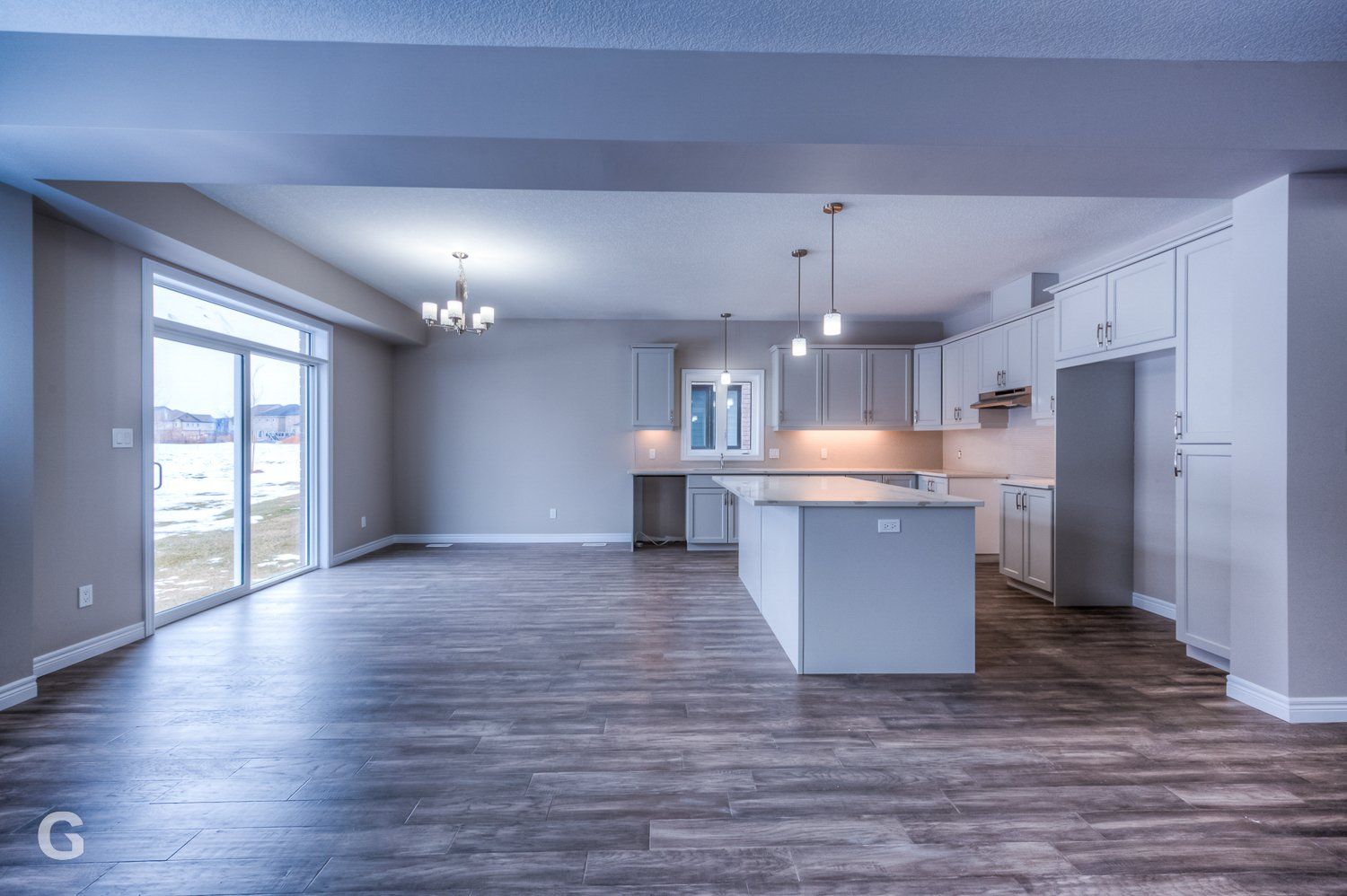 An empty kitchen with a large island in the middle of the room.