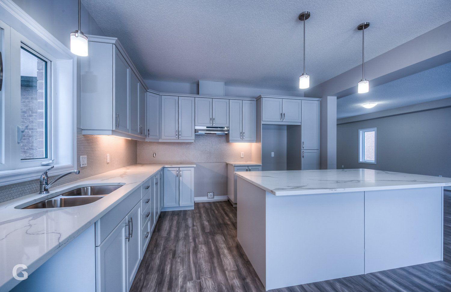 An empty kitchen with white cabinets and a large island