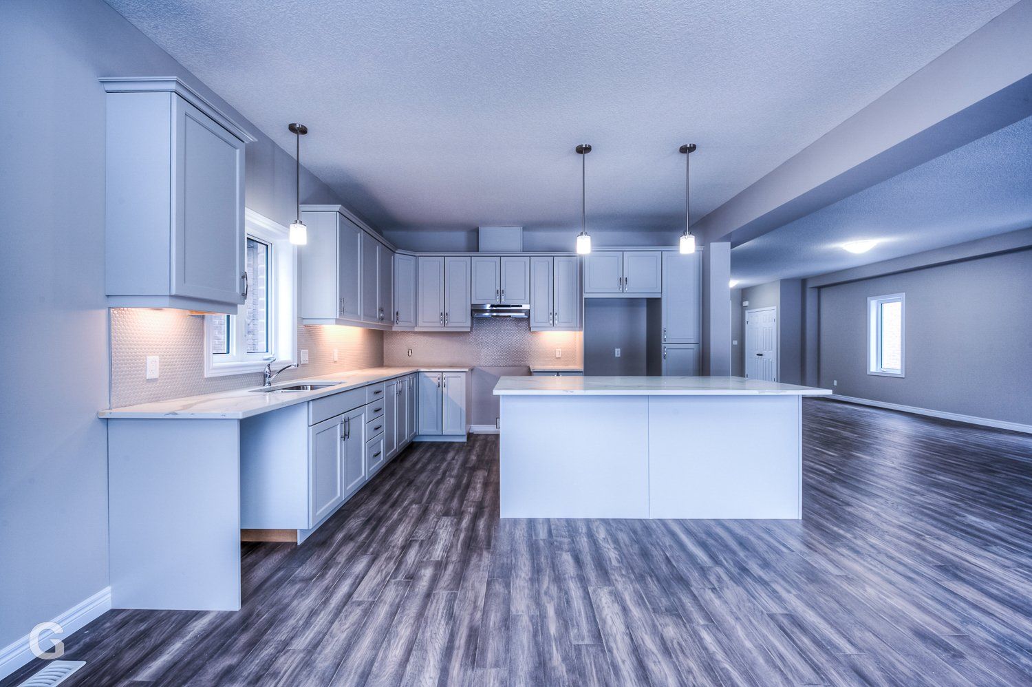 An empty kitchen with a large island in the middle