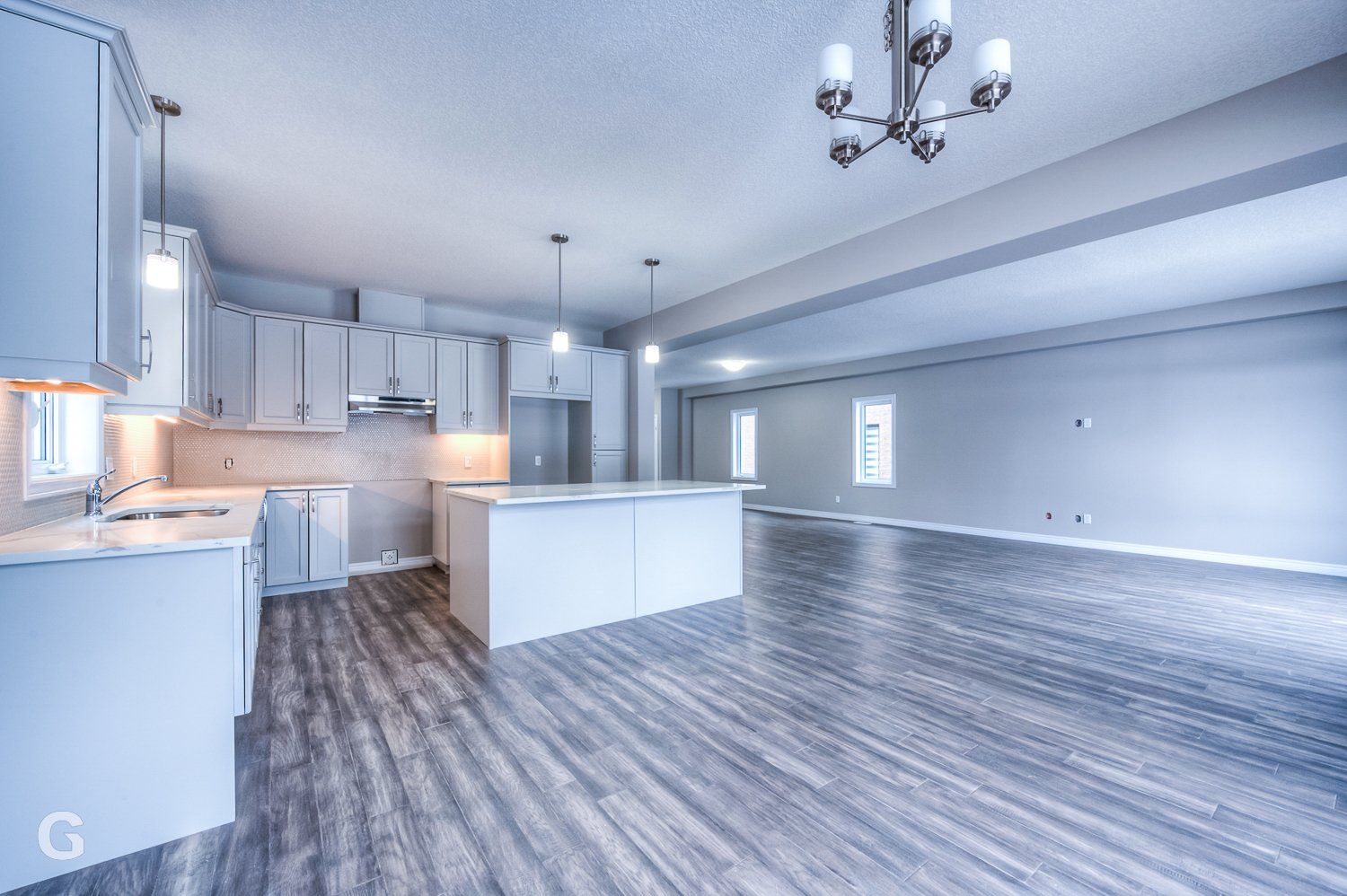 An empty kitchen with white cabinets and a large island