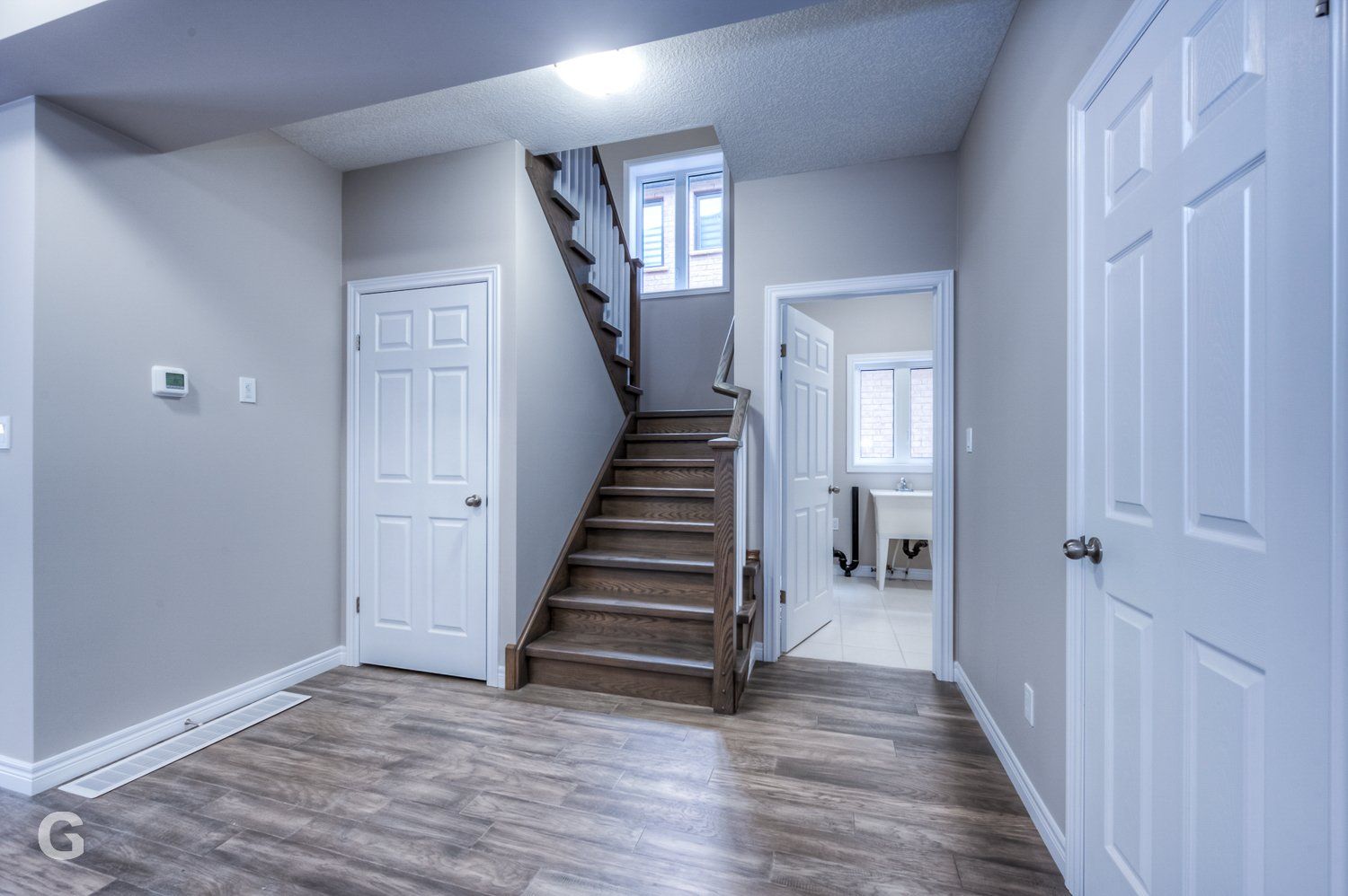 A hallway with stairs leading up to the second floor of a house.