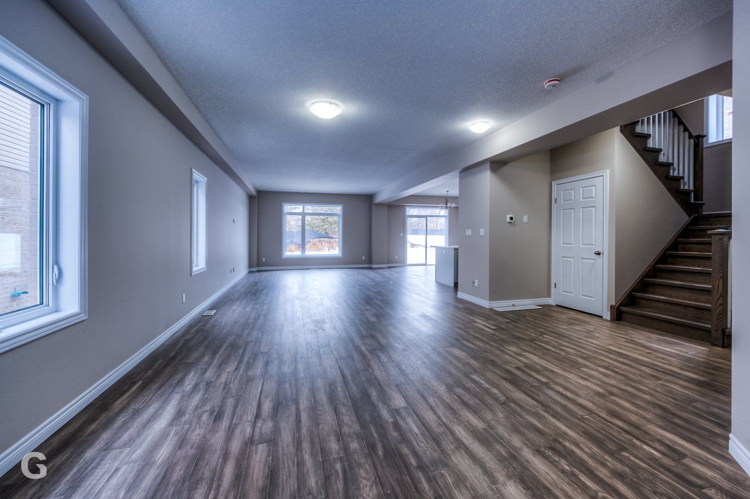 A large empty room with hardwood floors and stairs