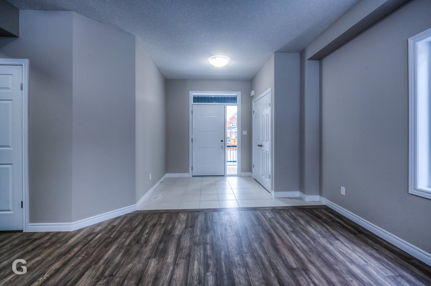 An empty room with hardwood floors and a door