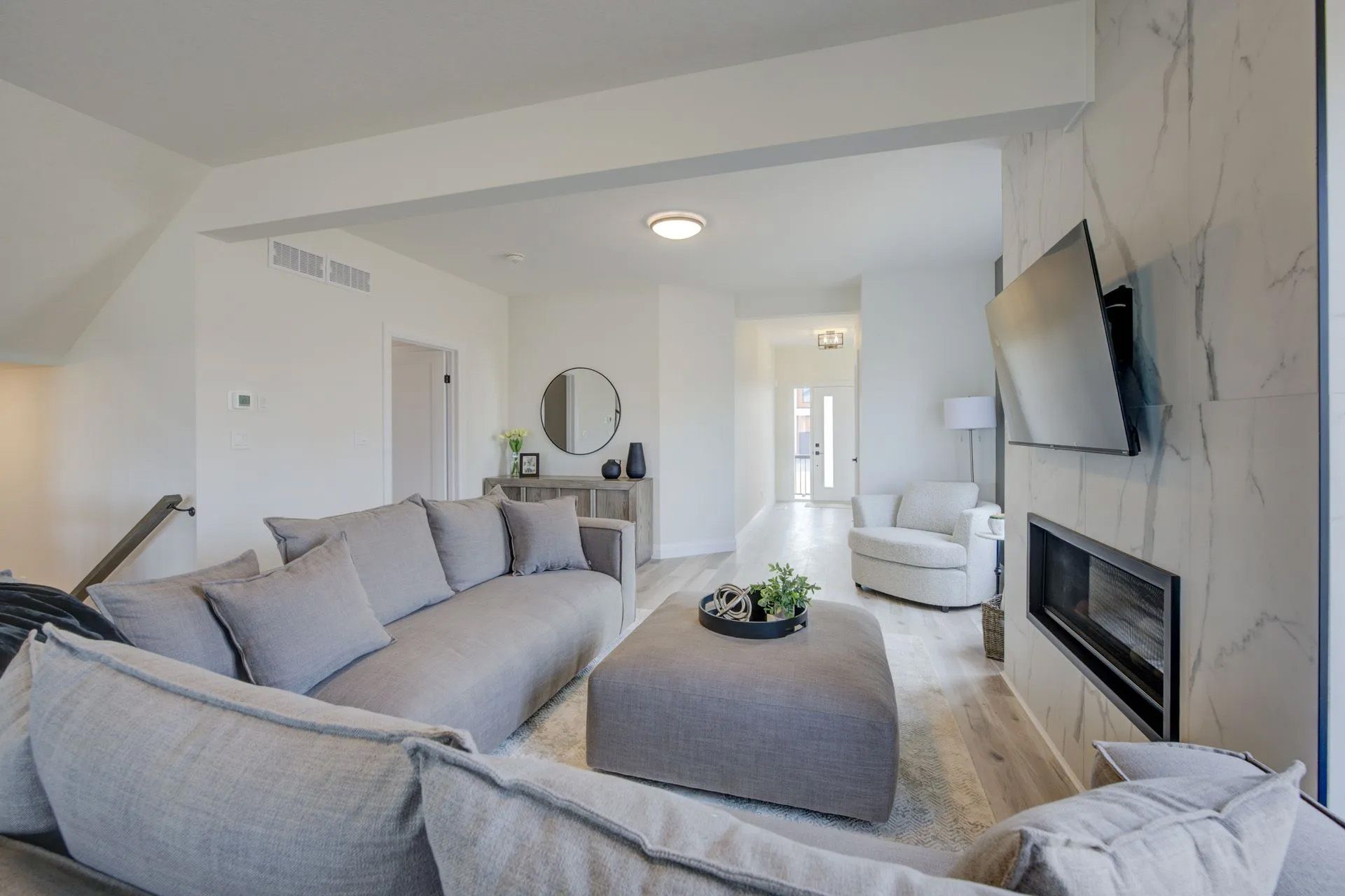 A living room with a couch , chairs , coffee table and television.
