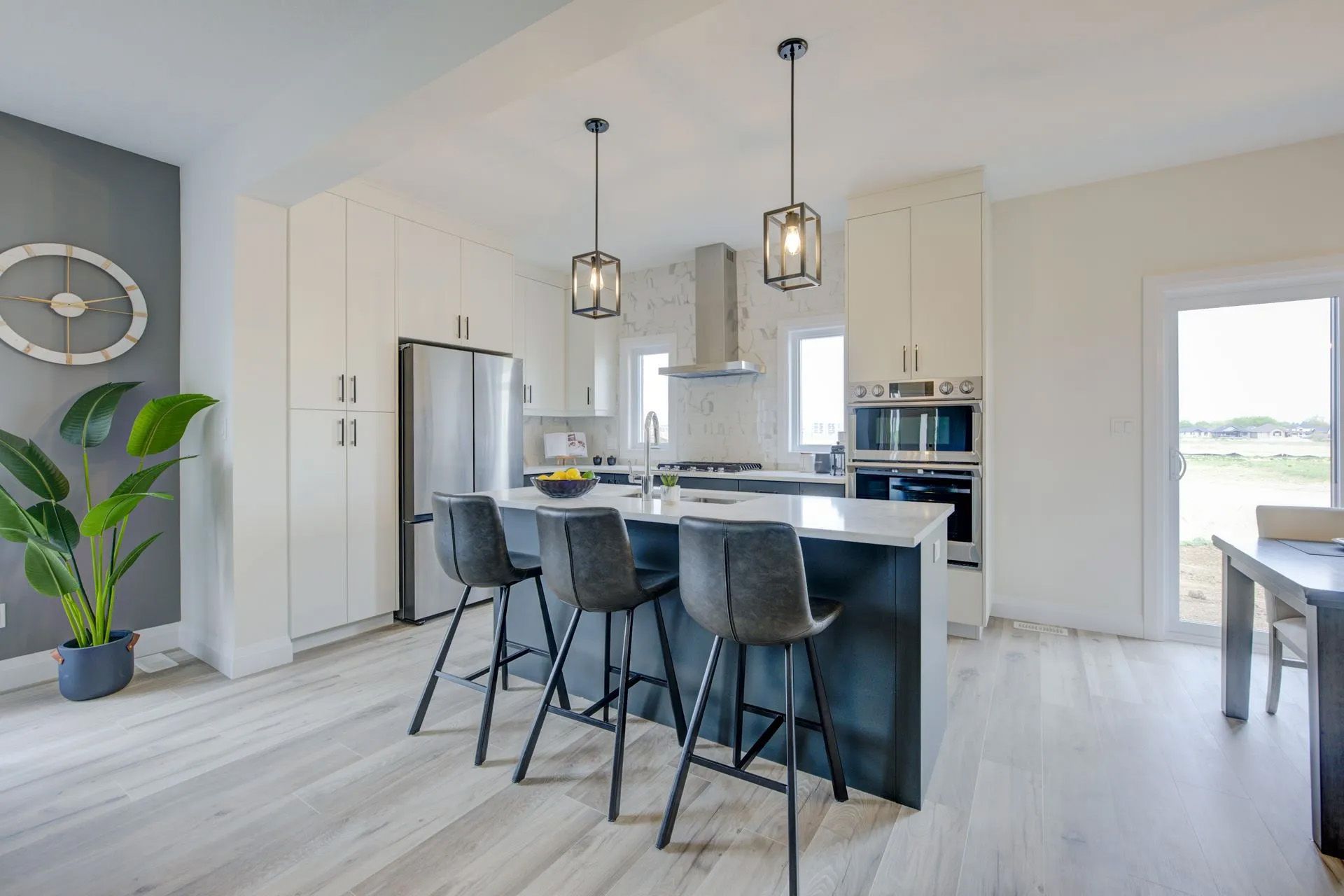 A kitchen with a large island and stools in it.