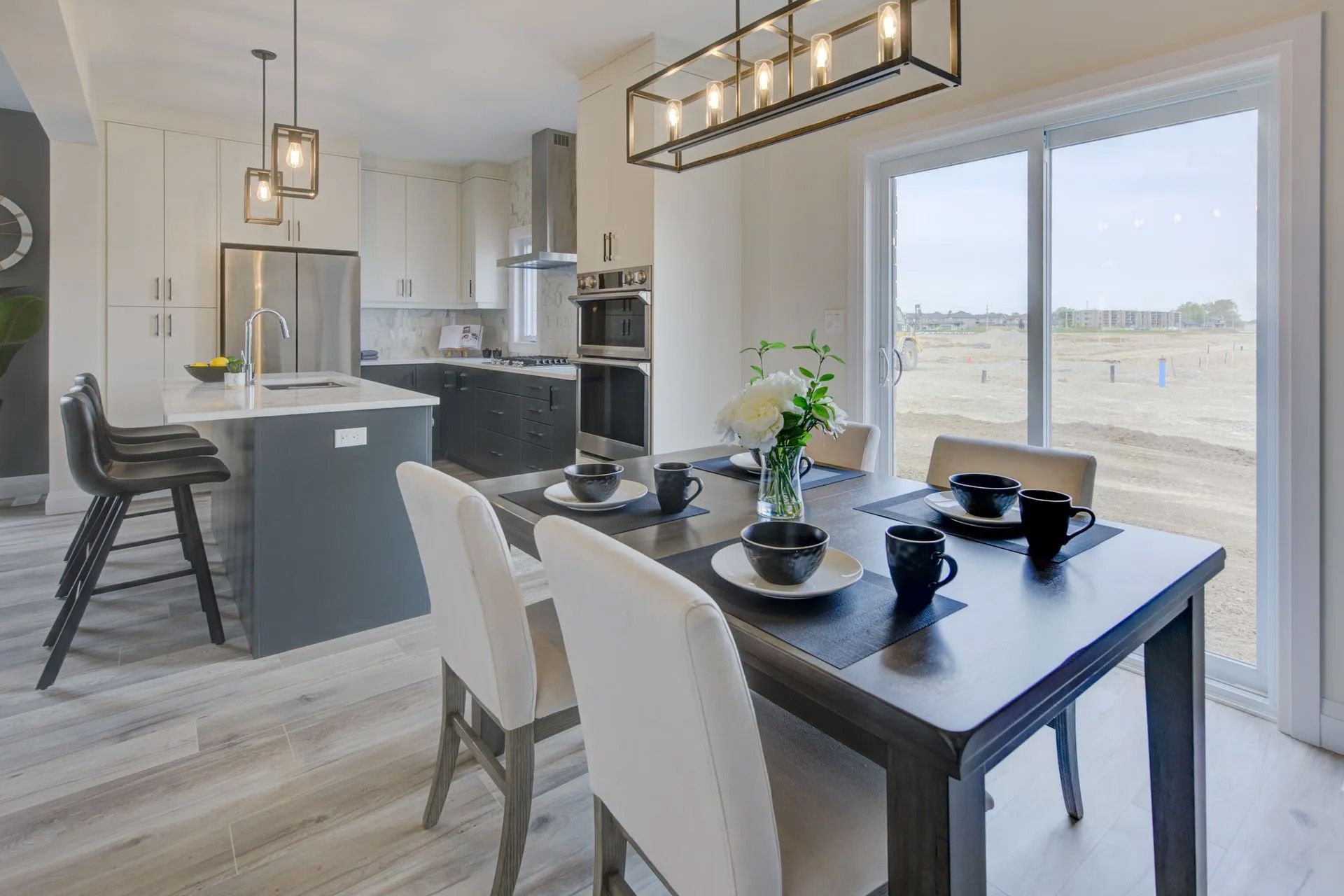 A dining room table and chairs in a kitchen with a sliding glass door.