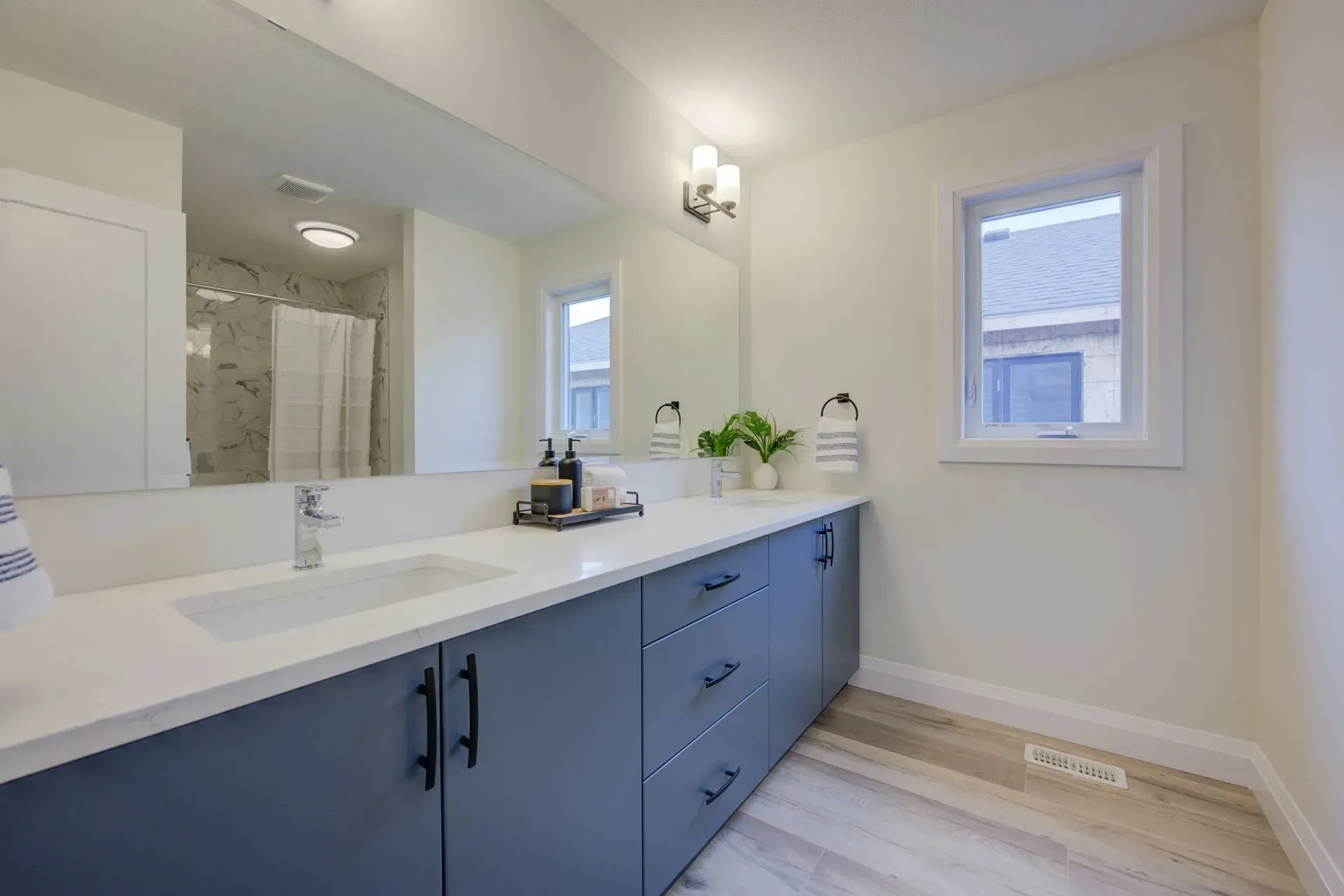 A bathroom with two sinks and a large mirror.