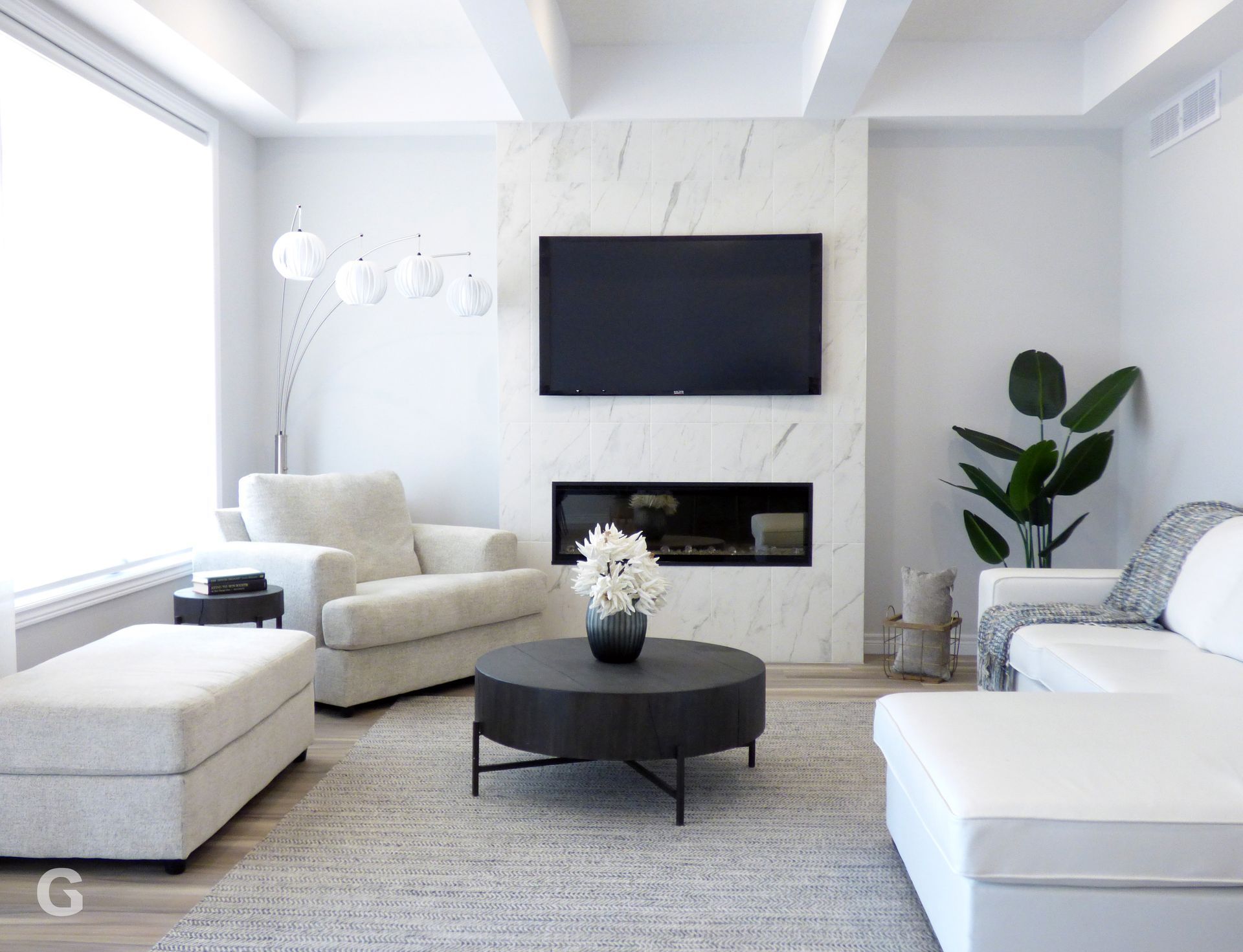 A living room with white furniture and a flat screen tv
