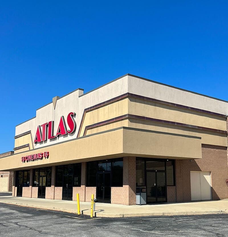 Exterior view of the Atlas Fitness building with a red sign against a clear blue sky.