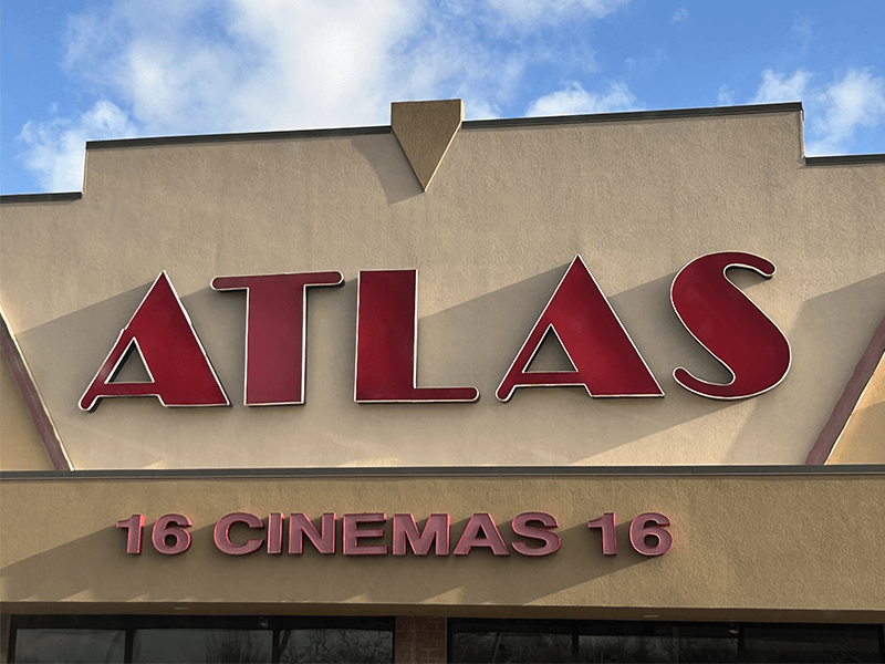 Atlas Cinemas exterior, red letters on a beige building, blue sky, 