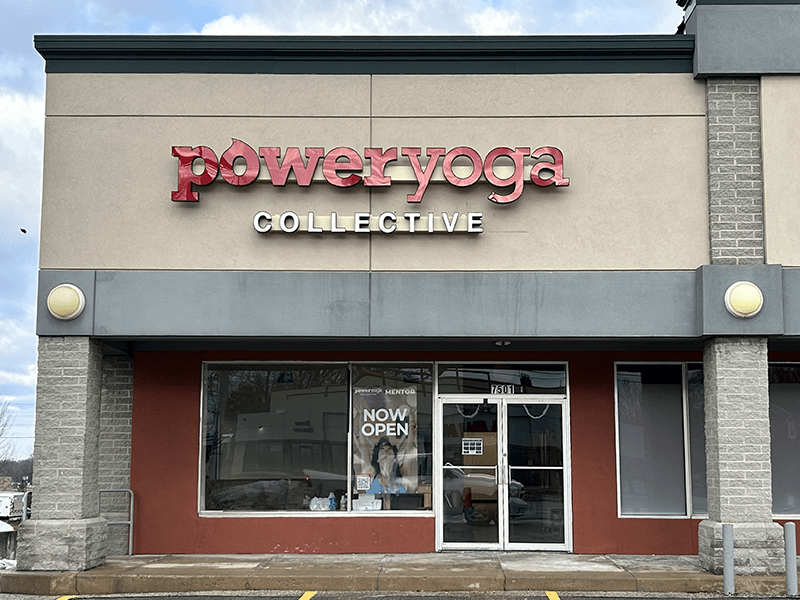 Power Yoga Collective storefront with red sign; tan building exterior; 