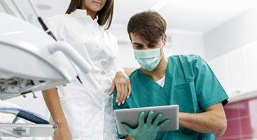 dentist with dental assistant using tablet