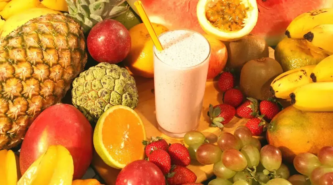 A colorful table of healthy foods including greens, fruits, and water to support oral health while dieting.