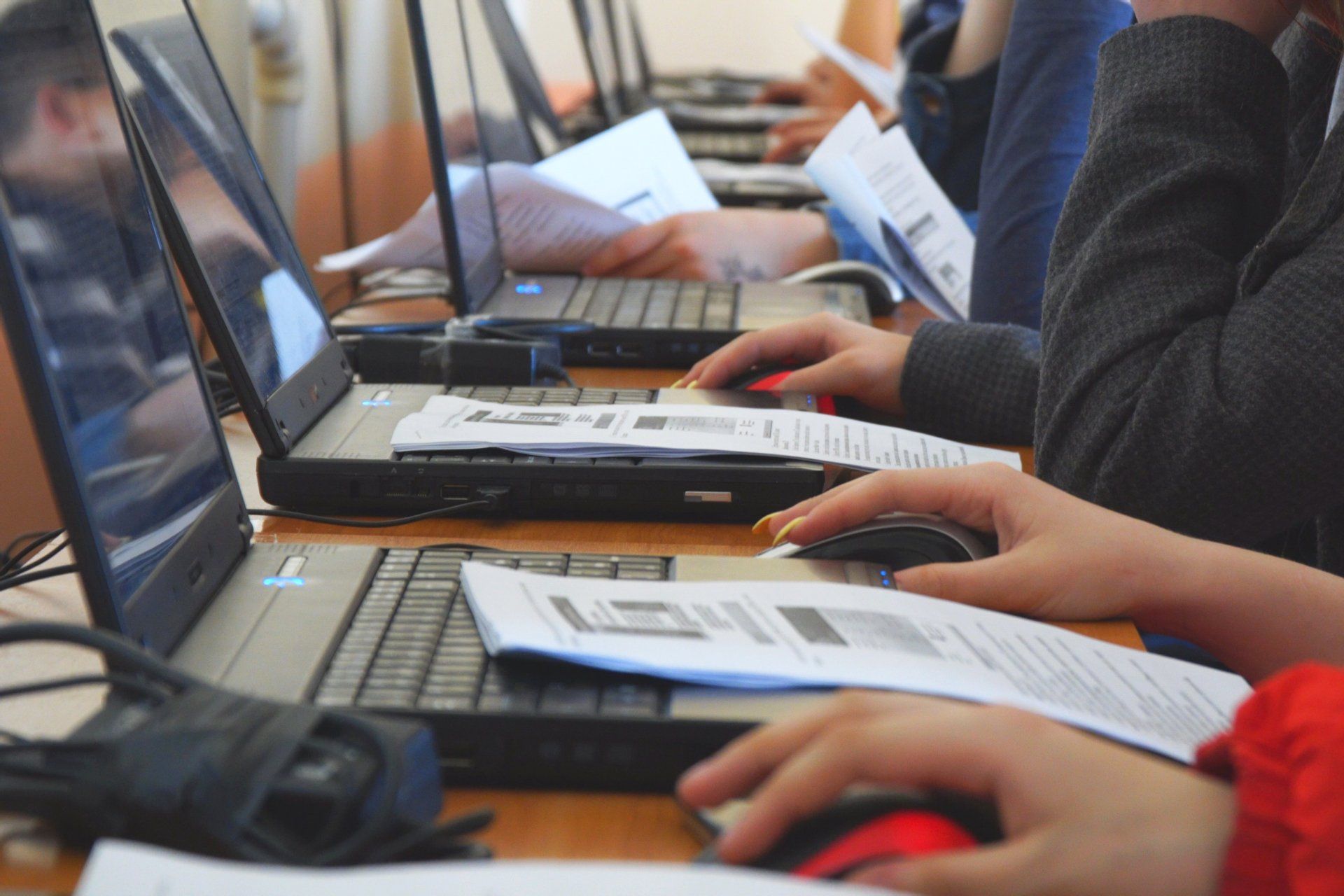 A group of people are sitting at a table using laptops