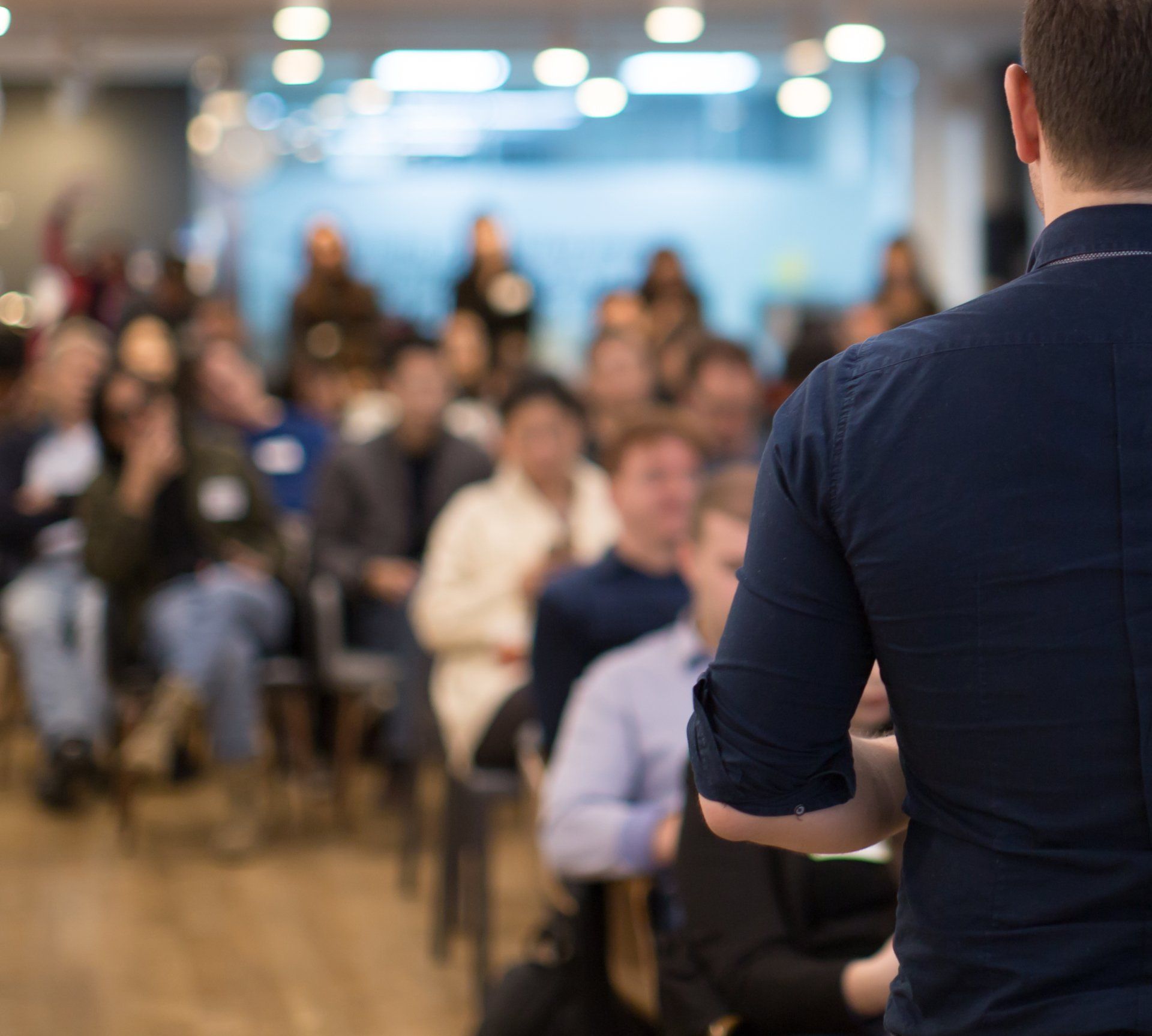 A man is giving a presentation to a group of people sitting in chairs.
