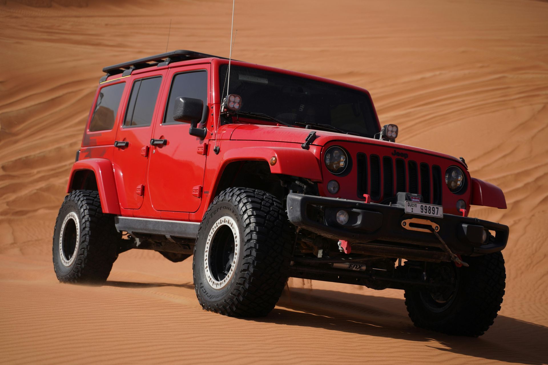 Red off-road vehicle with tinted windows that reduce glare and heat rejection under the sun.