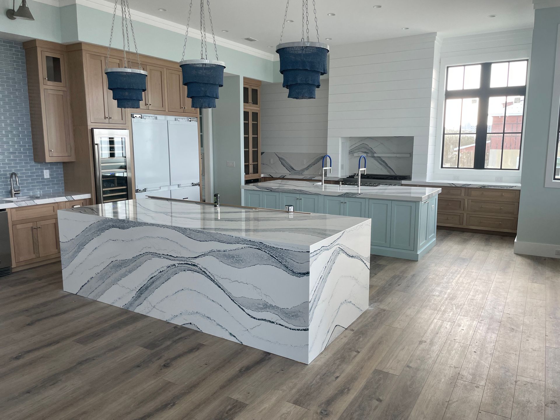 Person installing kitchen cabinet, tools nearby.