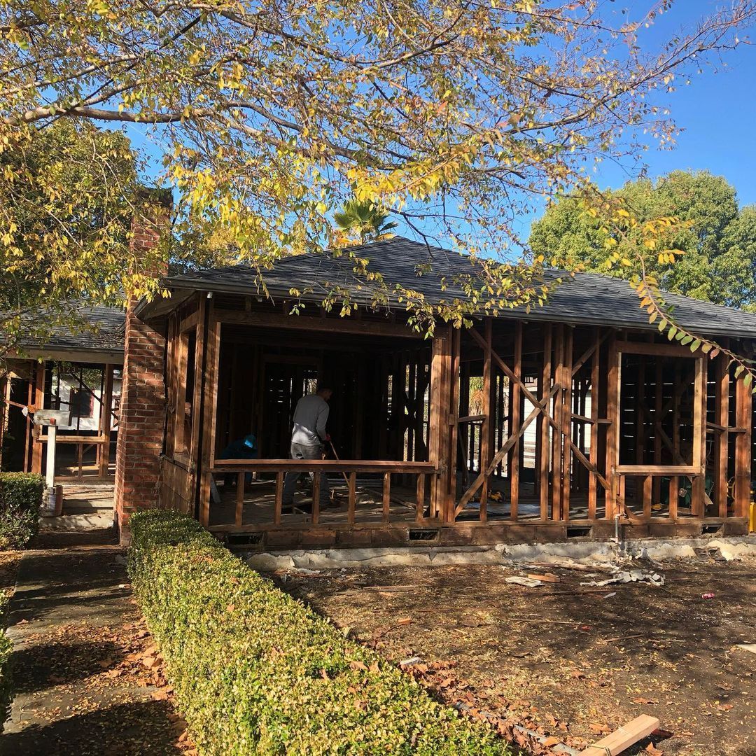 A man is standing in front of a house under construction.