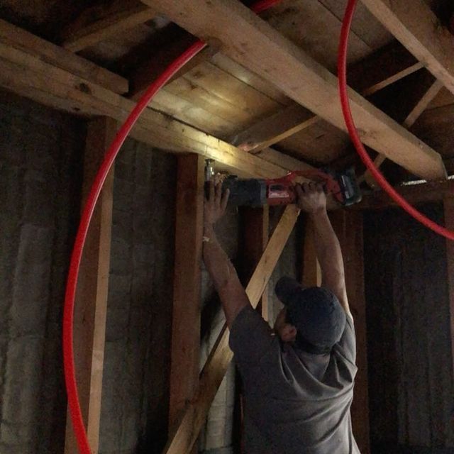 A man is working on a wooden structure with a drill