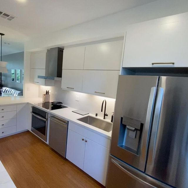 A kitchen with stainless steel appliances and white cabinets