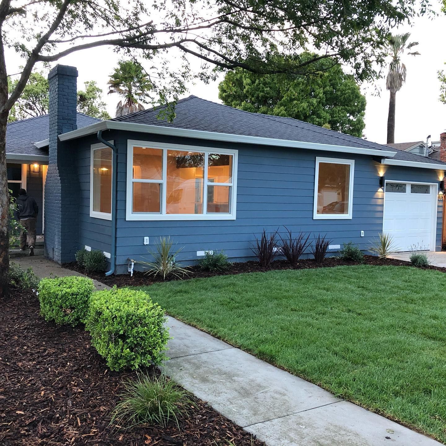 A blue house with a lot of windows and a garage