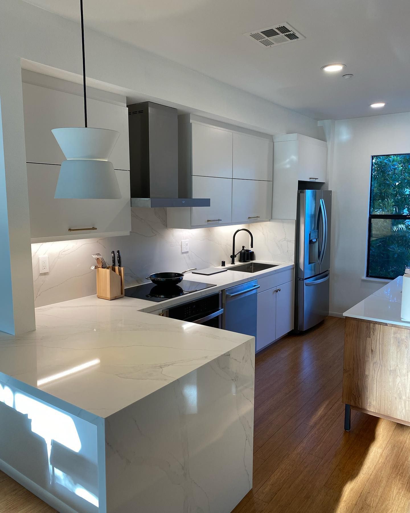 A kitchen with white cabinets and stainless steel appliances.