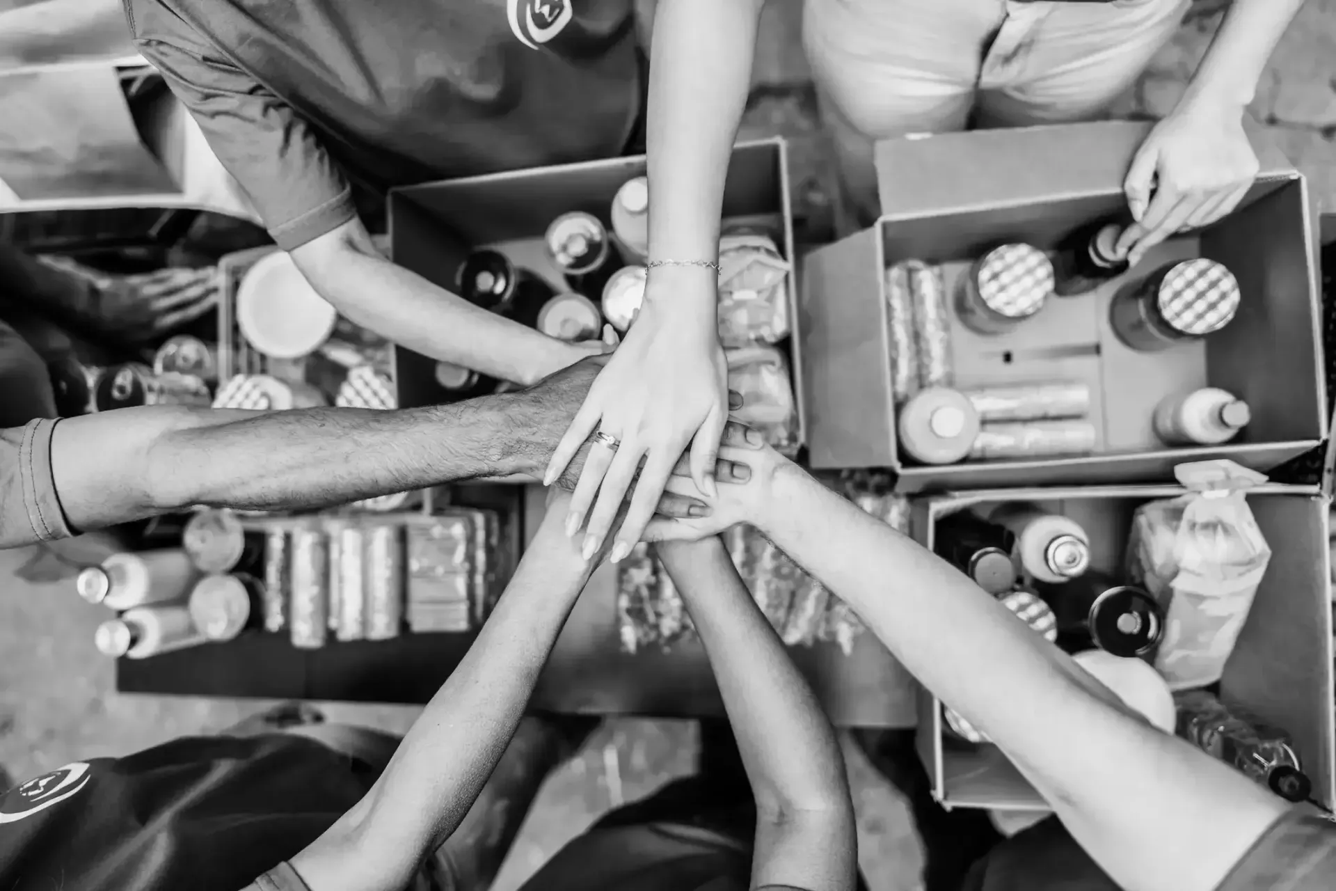 A group of people are putting their hands together in a circle.