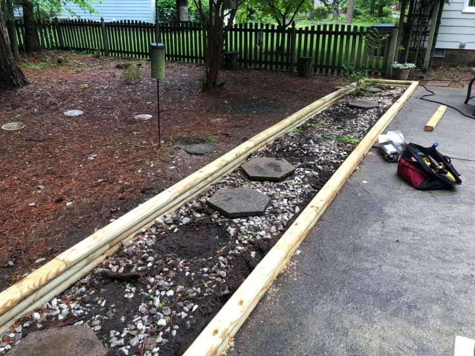 A wooden fence is being built in a backyard
