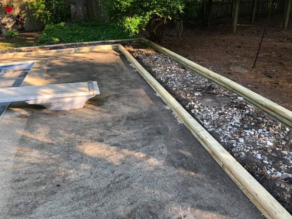 A wooden fence is being built in a backyard.