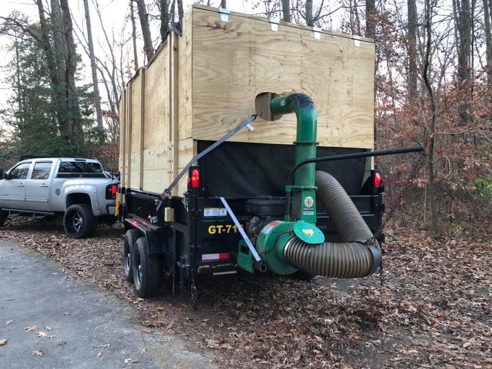 A truck is towing a trailer with a leaf blower attached to it.