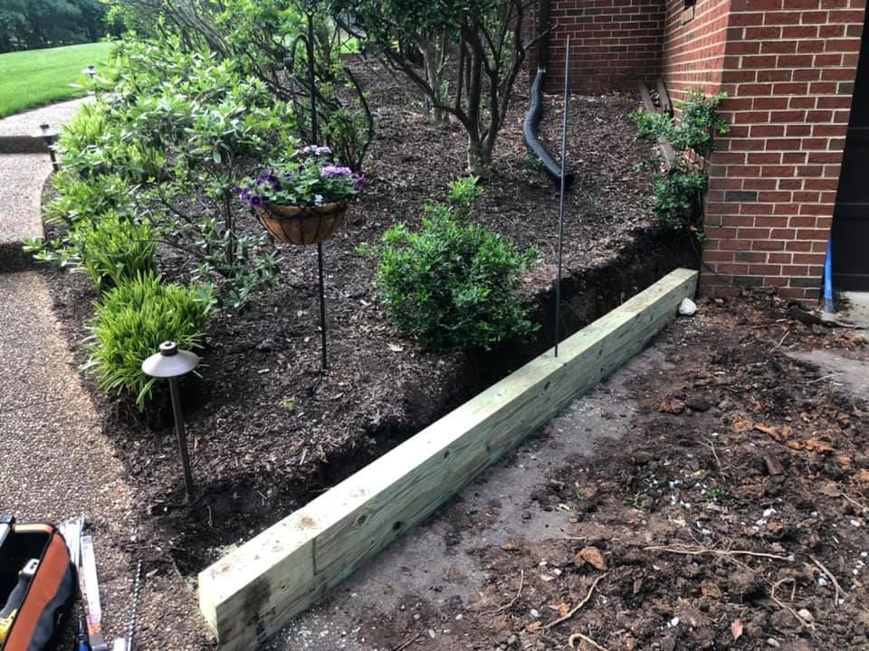 A wooden fence is being built in front of a brick building.
