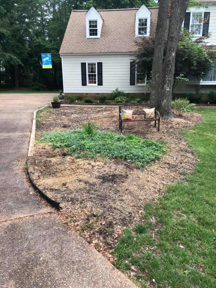 A white house with a brown roof and a bench in front of it.