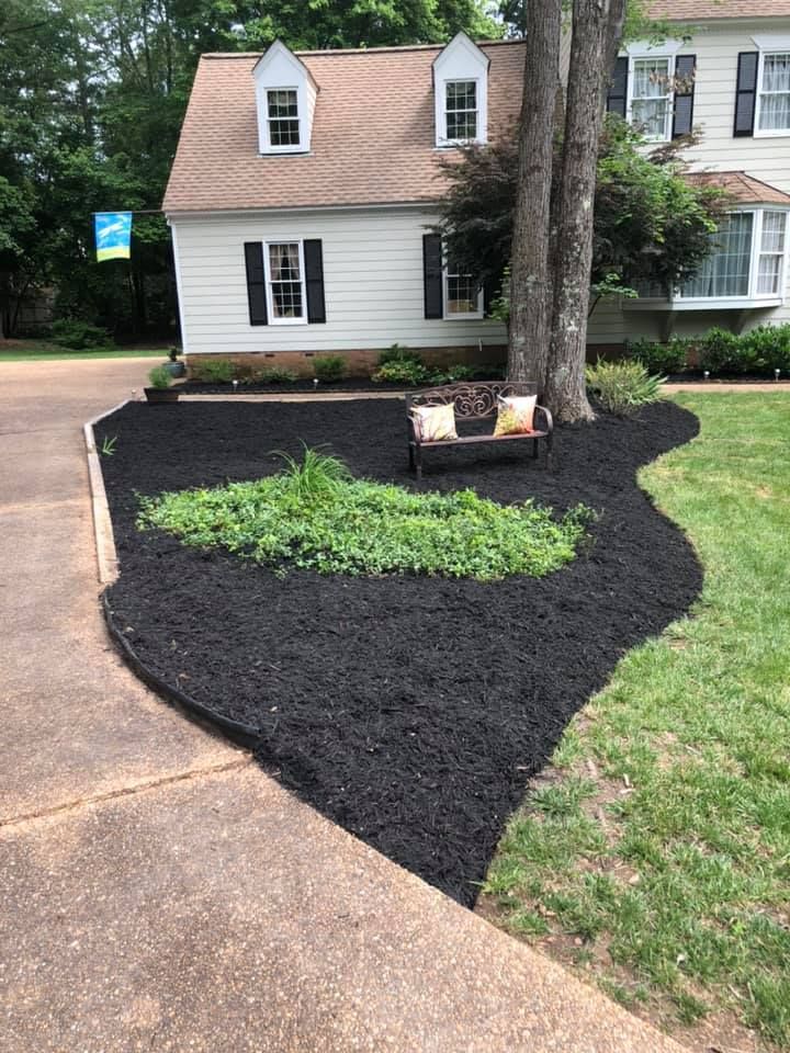 There is a bench in the middle of the yard in front of the house.