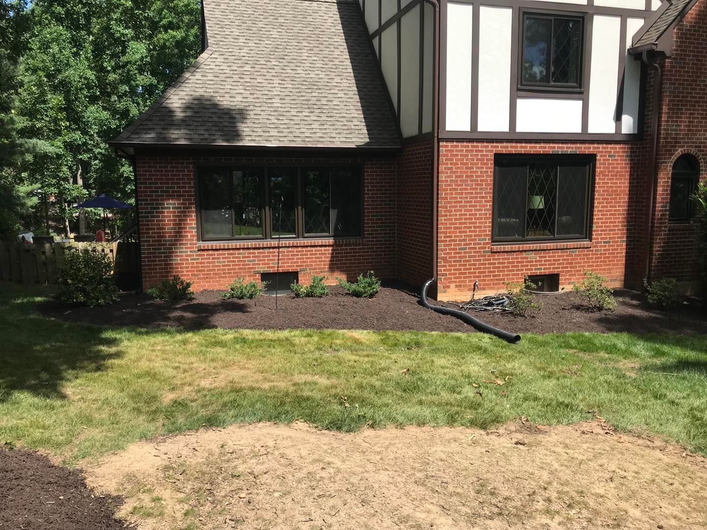 A brick house with a large lawn in front of it.