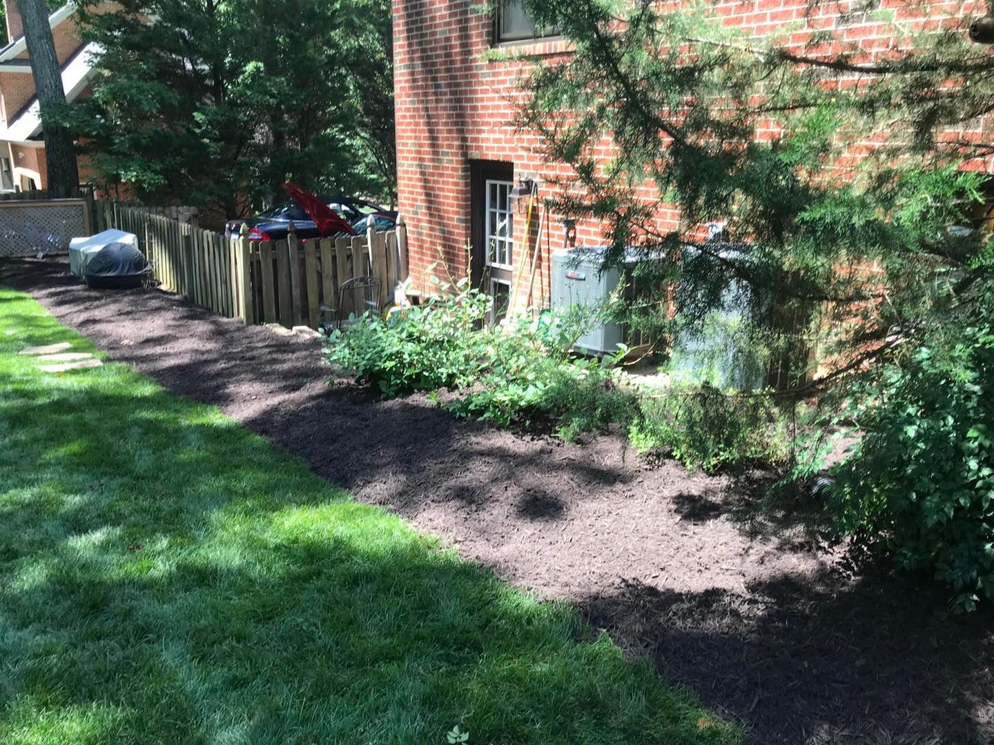 A lush green yard with a brick building in the background