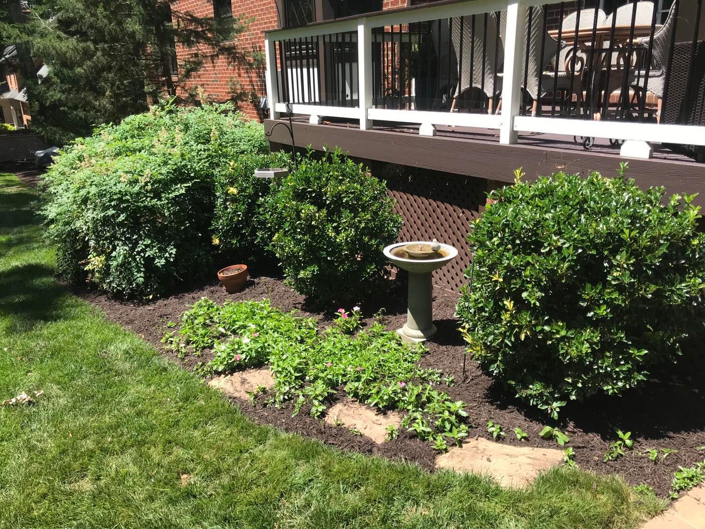 There is a bird bath in the middle of the yard.