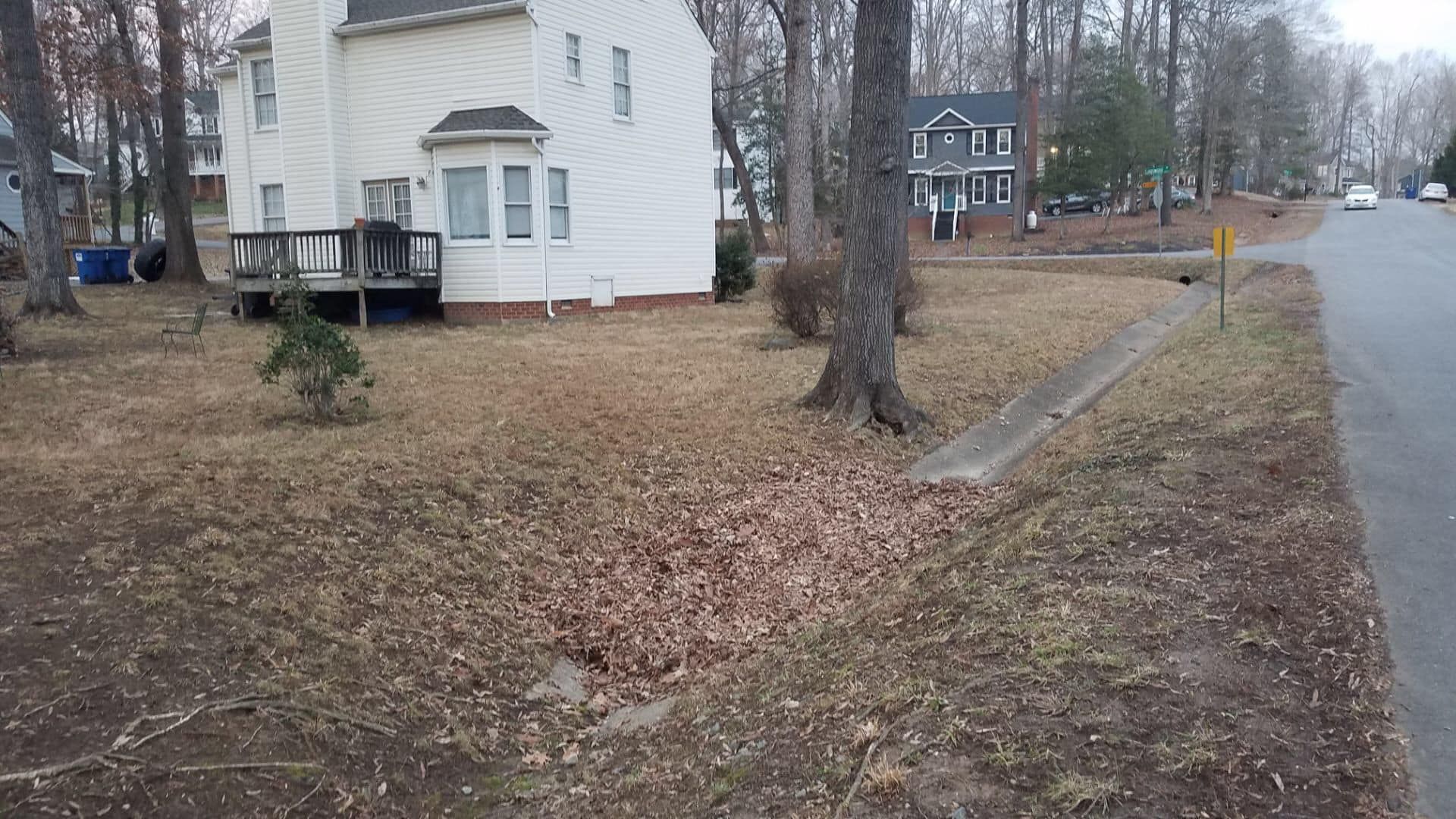 A white house sits on the corner of a residential street
