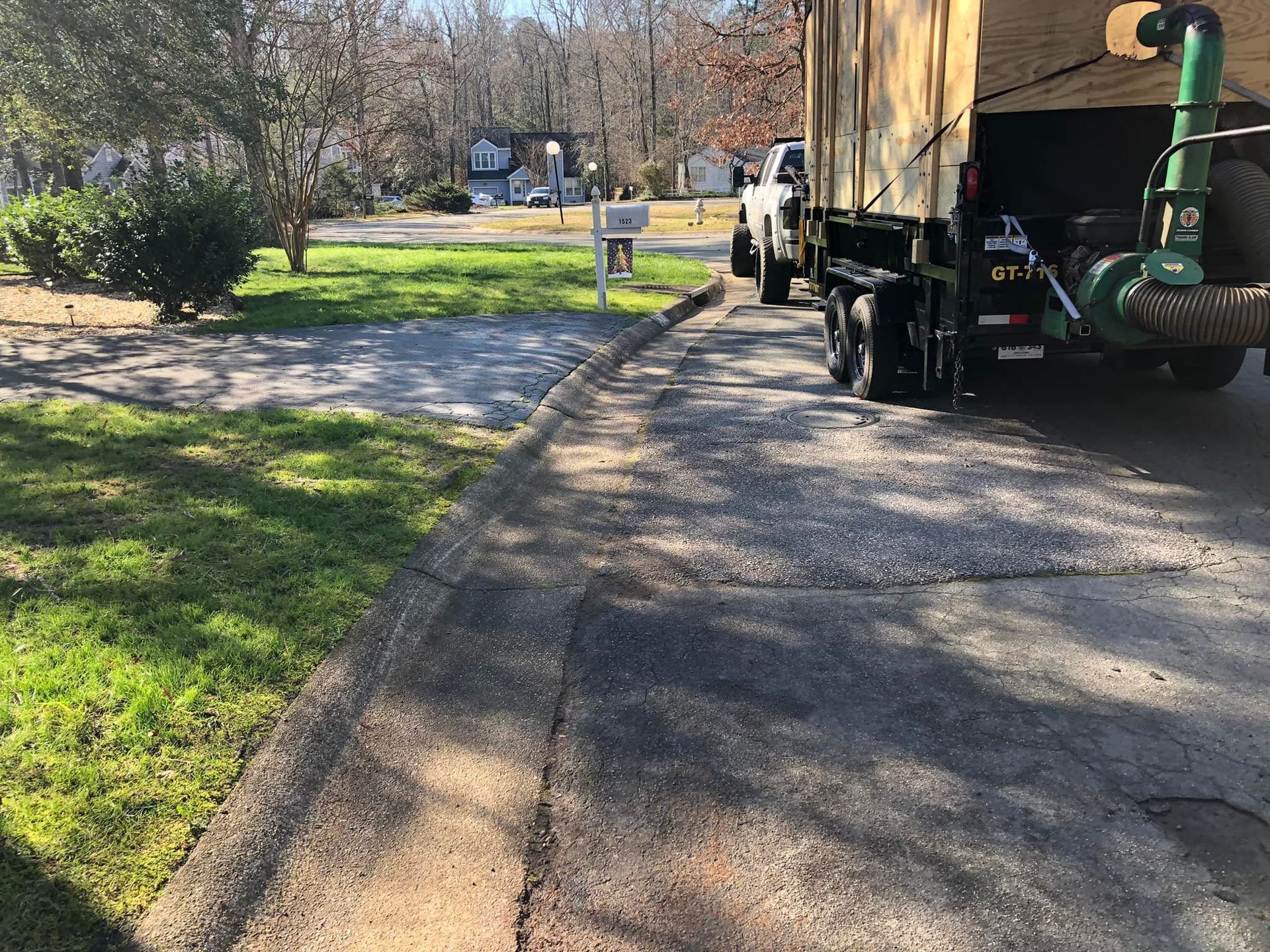 A truck with a leaf blower attached to it is parked in a driveway.