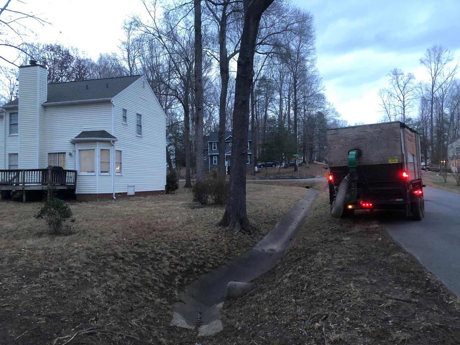 A truck is parked on the side of the road in front of a house