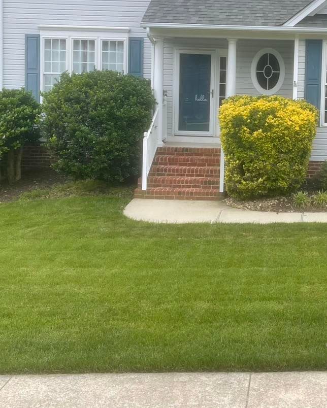 A house with a lush green lawn in front of it