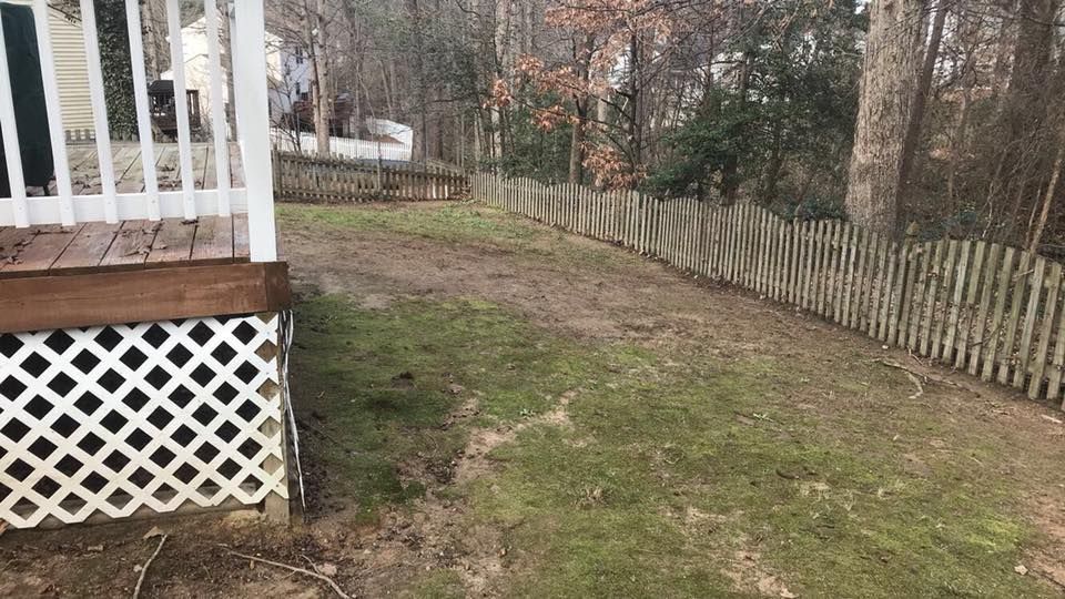 A wooden deck with a white picket fence surrounding it.