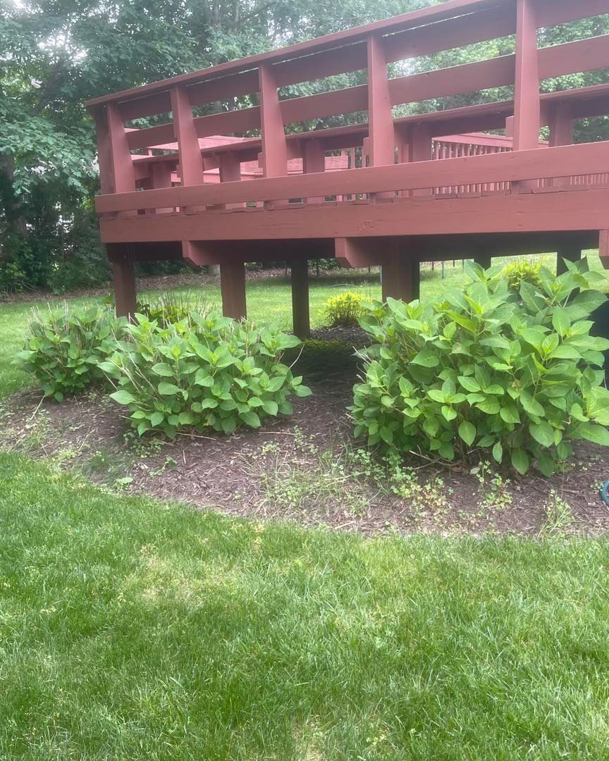 A wooden bridge is sitting on top of a lush green lawn.