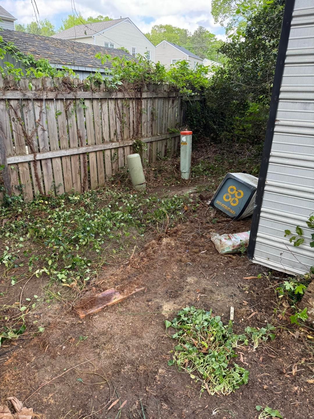 A backyard with a wooden fence and a metal shed.