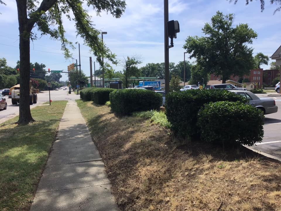A car is parked on the side of the road next to a sidewalk