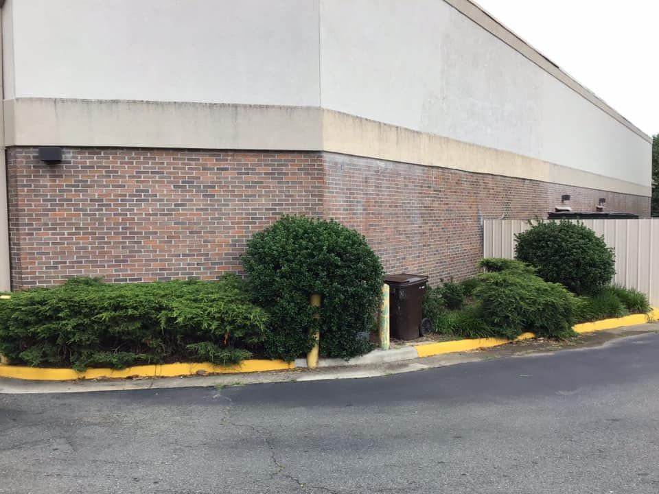 A brick building with a white roof and a yellow curb