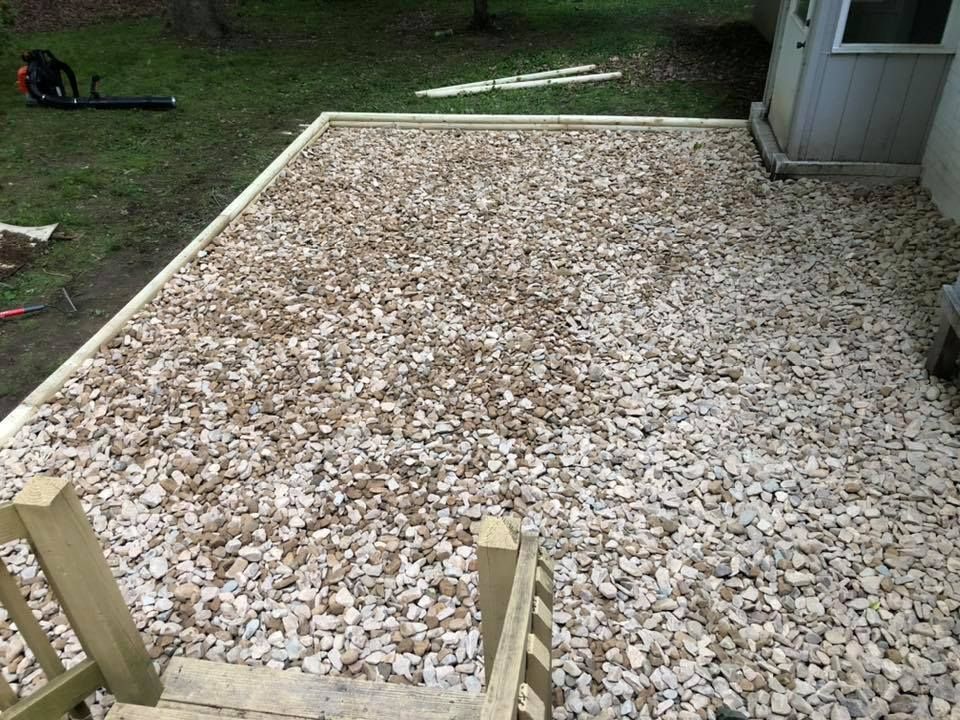 A deck is being built with gravel and wooden steps.